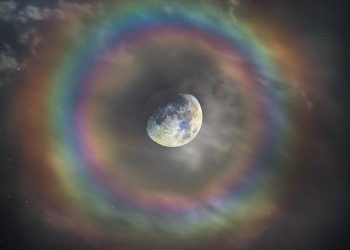 Une image saisissante montre la lune entourée d’un arc-en-ciel céleste, la lumière réfléchie par sa surface argentée étant diffractée par les particules d’eau dans l’air