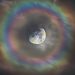 Une image saisissante montre la lune entourée d’un arc-en-ciel céleste, la lumière réfléchie par sa surface argentée étant diffractée par les particules d’eau dans l’air