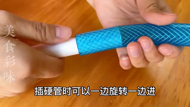 Insertion du tube rigide blanc dans le tuyau souple bleu en tournant.