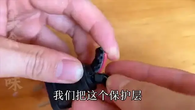 Le manchon de protection est écarté, révélant les fils internes courts