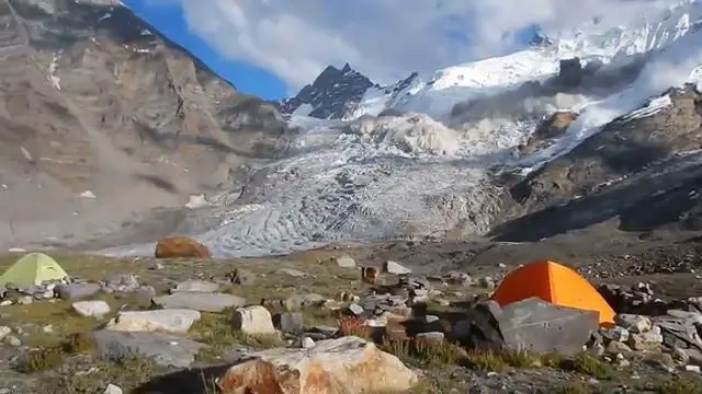 Une avalanche massive de neige fonce droit sur un campement de tentes en montagne