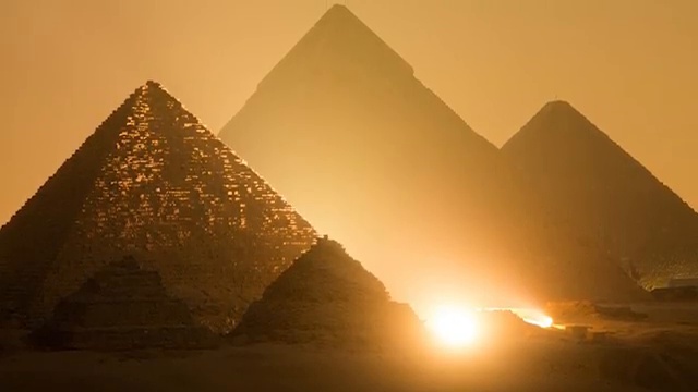 Vue majestueuse des trois grandes pyramides de Gizeh au coucher du soleil, illustrant les théories d'alignement astronomique.