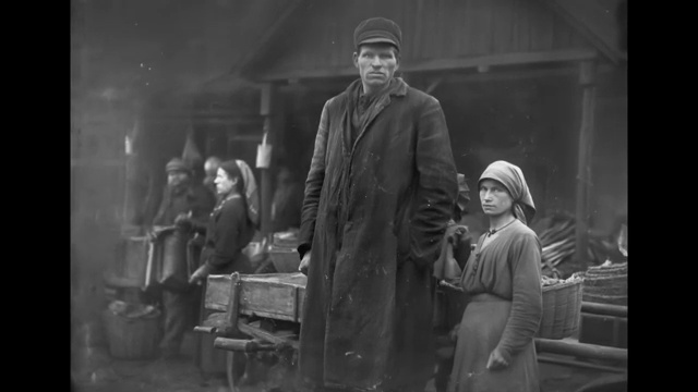 Photographie ancienne montrant un homme d'une taille gigantesque se tenant aux côtés de bûcherons de taille normale dans la neige.