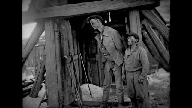 Vue détaillée d'une scie passe-partout gigantesque et d'un traîneau de transport aux dimensions inadaptées pour un homme moyen.