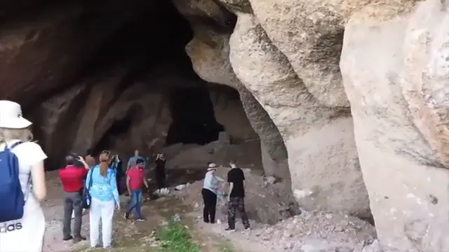 Exploration d'une cavité souterraine révélant que les fondations mégalithiques s'étendent profondément sous le niveau du sol actuel.