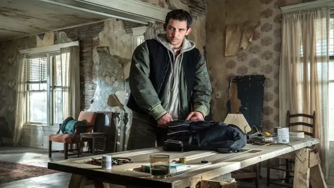 un homme dans une maison en train de vider un sac à dos