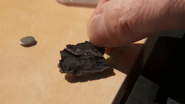 Gros plan sur un étrange fragment métallique exhumé par le géologue Frank Kimbler sur le site du crash de Roswell.