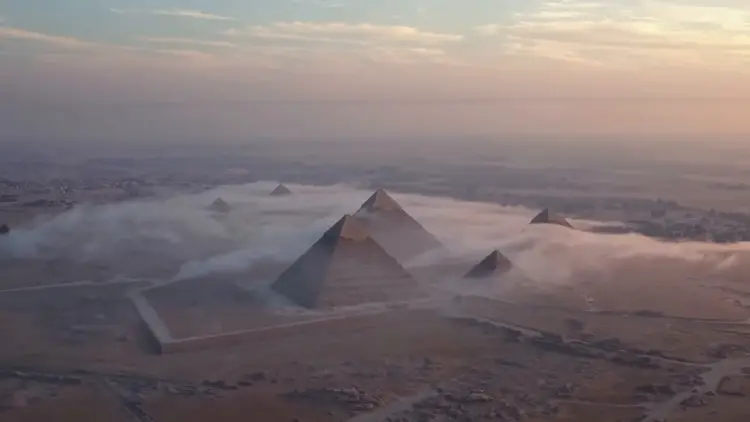 Vue aérienne des pyramides de Gizeh émergeant de la brume.