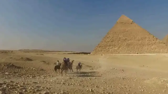 Vue panoramique des pyramides de Gizeh, soulignant les structures monumentales dont la construction reste un sujet de débat.