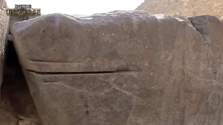 Détail de marques de scie profondes et rectilignes sur une pierre massive, illustrant les techniques de découpe sophistiquées.